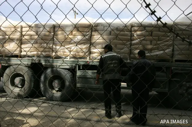 Palestinians check trucks loaded with construction materials at the Rafah crossing which entered through Israel's Kerem Shalom crossing in southern Gaza Strip on November 16, 2011. Israel allowed to enter the constructio...