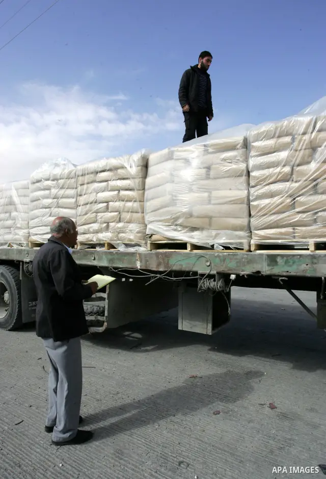 Palestinians check trucks loaded with construction materials at the Rafah crossing which entered through Israel's Kerem Shalom crossing in southern Gaza Strip on November 16, 2011. Israel allowed to enter the constructio...