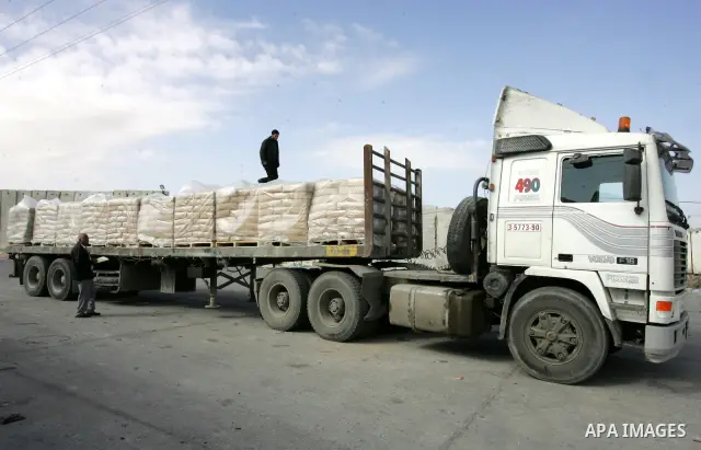 Palestinians check trucks loaded with construction materials at the Rafah crossing which entered through Israel's Kerem Shalom crossing in southern Gaza Strip on November 16, 2011. Israel allowed to enter the constructio...
