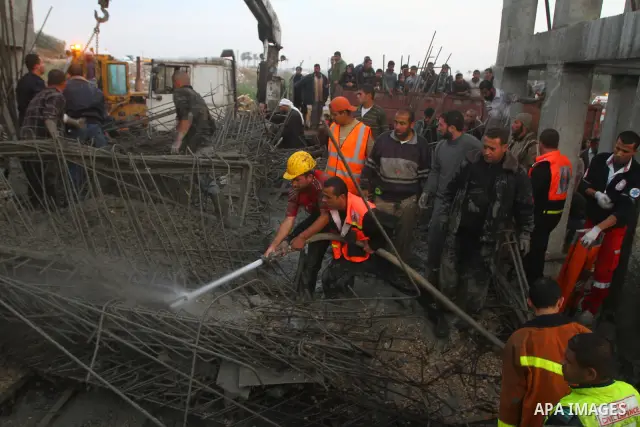 Palestinian rescue teams inspect the scene of a collapsed bridge on a main road in the central Gaza Strip that links Gaza City with the south, near Nusseirat, on November 17, 2011. Medical sources said two Palestinian wo...