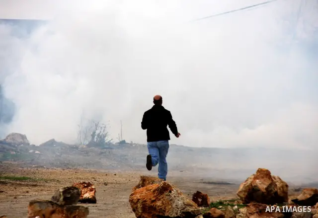 Palestinians run away from tear gas fired by Israeli security forces, who are seeking access to their land near Kufr Qaddum, near the northern West Bank Jewish settlement of Kdumim, Friday, Nov. 18, 2011. Photo by Wagdi...