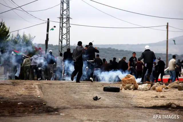 Palestinians run away from tear gas fired by Israeli security forces, who are seeking access to their land near Kufr Qaddum, near the northern West Bank Jewish settlement of Kdumim, Friday, Nov. 18, 2011. Photo by Wagdi...