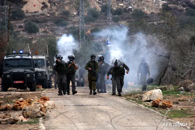 Israeli border police officers fire tear gas toward Palestinian demonstrators, who are seeking access to their land near Kufr Qaddum, near the northern West Bank Jewish settlement of Kdumim, Friday, Nov. 18, 2011. Photo...