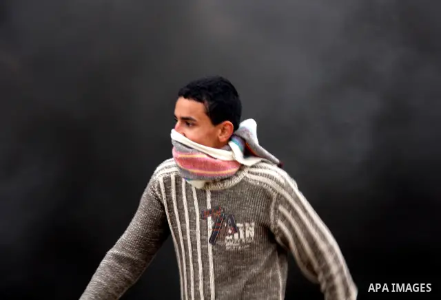 Palestinians run away from tear gas fired by Israeli security forces, who are seeking access to their land near Kufr Qaddum, near the northern West Bank Jewish settlement of Kdumim, Friday, Nov. 18, 2011. Photo by Wagdi...