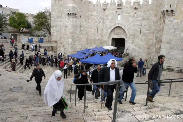 Palestinians walk outside Damascus Gate leading into the old city of Jerusalem from their way from Friday prayers in the Al-Aqsa Mosque compound, Islam's third holiest site, on November 18, 2011. Photo by Mahfouz Abu Tur...