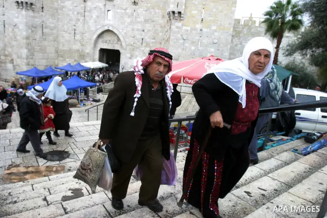 Palestinians walk outside Damascus Gate leading into the old city of Jerusalem from their way from Friday prayers in the Al-Aqsa Mosque compound, Islam's third holiest site, on November 18, 2011. Photo by Mahfouz Abu Tur...