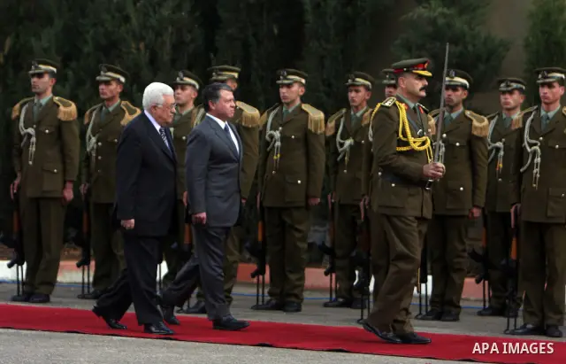 Palestinian President Mahmoud Abbas and King Abdullah of Jordan walk together during a welcoming ceremony in the West Bank city of Ramallah November 21, 2011. Abdullah arrived in Ramallah on Monday for a rare visit to th...