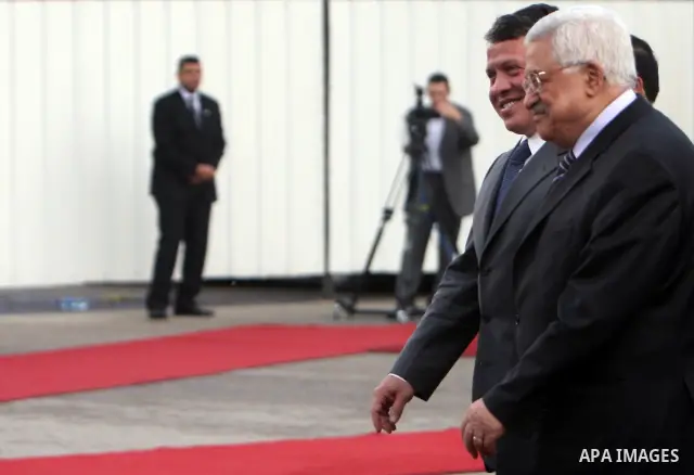Palestinian President Mahmoud Abbas and King Abdullah of Jordan walk together during a welcoming ceremony in the West Bank city of Ramallah November 21, 2011. Abdullah arrived in Ramallah on Monday for a rare visit to th...