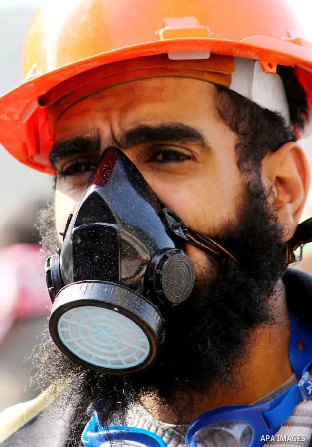 A protester looks on as he wears a mask during clashes with the Egyptian riot police near Tahrir square in Cairo, Egypt, Tuesday, Nov. 22, 2011. Egypt's ruling military moved up the date for transferring power to a civil...