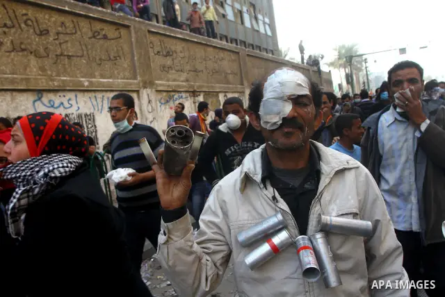 An injured protester hangs spent police tear gas canisters around his neck during clashes with riot police in a side street near Tahrir Square in Cairo November 22, 2011. Photo by Ashraf Amra