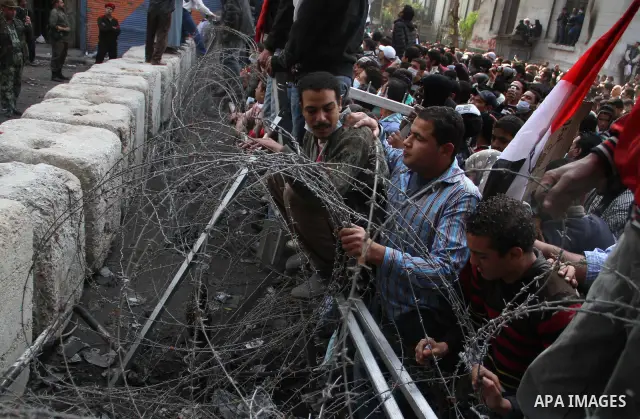 Egyptian protesters gather near barbed wire and concrete barricades around the Interior Ministry, near Cairo's Tahrir Square, November 24, 2011. A truce between Egyptian riot police and protesters succeeded on Thursday i...