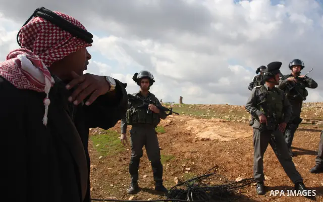 A Palestinian man from the Bedouin Abu Mansor family stands as Israeli forces destroy his family house in an area of the east Jerusalem neighborhood of Beit Hanina which falls in the West Bank side of Israel's separation...