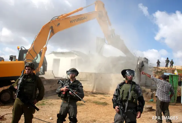 A Palestinian man from the Bedouin Abu Mansor family stands as Israeli forces destroy his family house in an area of the east Jerusalem neighborhood of Beit Hanina which falls in the West Bank side of Israel's separation...