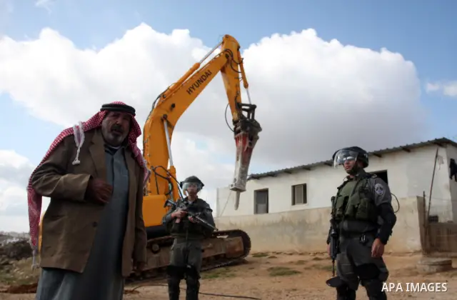 A Palestinian man from the Bedouin Abu Mansor family stands as Israeli forces destroy his family house in an area of the east Jerusalem neighborhood of Beit Hanina which falls in the West Bank side of Israel's separation...
