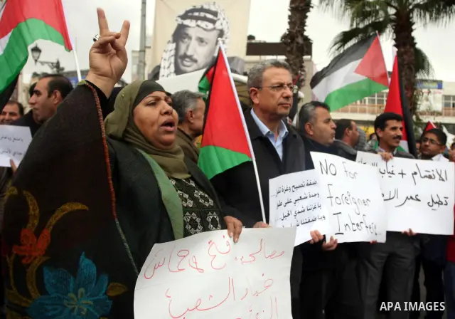 Palestinians hold placards during a rally supporting the unification between rival Palestinian factions Fatah and Hamas, in the West Bank city of Ramallah November 24, 2011. Palestinian President Mahmoud Abbas met Hamas...