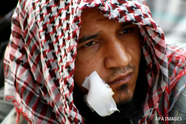 An injured Egyptian protester attends Friday prayers during a mass rally in Cairo's landmark Tahrir square on November 25, 2011 to demand an end to the military rule. The head of the military council tasked 79-year-old K...
