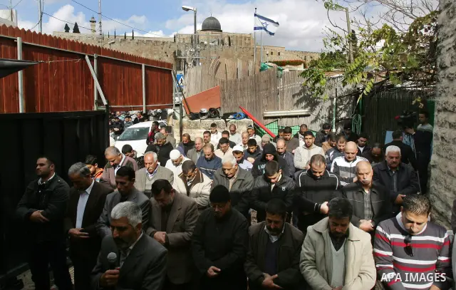 Palestinians attend Friday prayers inside the house of Samarin family which the Israeli authorities threatened to size it in Jerusalem's neighbourhood of Silwan on Nov. 25,2011. Photo by Mahfouz Abu Turk
