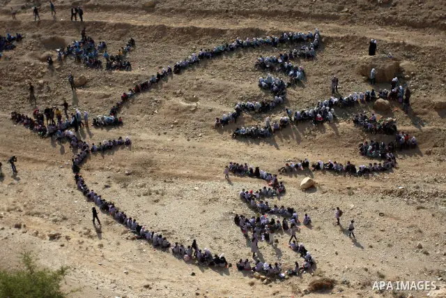Palestinian children stand to form Pablo Picasso's Dove of Peace as part of a project by British aerial artist John Quigley and the United Nations Relief Works Agency (UNRWA), at the foot of the Mount of Temptation in th...