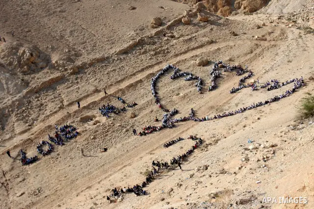 Palestinian children stand to form Pablo Picasso's Dove of Peace as part of a project by British aerial artist John Quigley and the United Nations Relief Works Agency (UNRWA), at the foot of the Mount of Temptation in th...