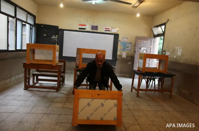 An Egyptian man carries an electoral box into a polling station at a school in Cairo on November 27, 2011 on the eve of the first parliament elections since the end of the 30-year rule of strongman Hosni Mubarak. Photo b...