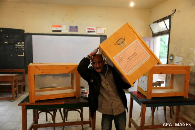 An Egyptian man carries an electoral box into a polling station at a school in Cairo on November 27, 2011 on the eve of the first parliament elections since the end of the 30-year rule of strongman Hosni Mubarak. Photo b...