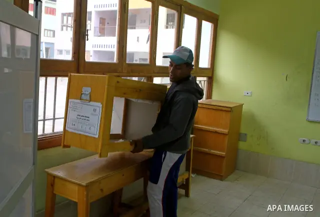 An Egyptian man carries an electoral box into a polling station at a school in Cairo on November 27, 2011 on the eve of the first parliament elections since the end of the 30-year rule of strongman Hosni Mubarak. Photo b...
