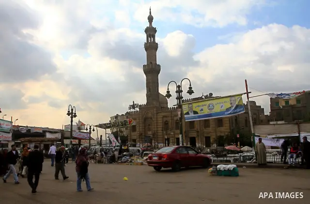 Egyptians walk past electoral campaign posters and banners for candidates in Cairo on November 27, 2011 on the eve of the first parliament elections since the end of the 30-year rule of strongman Hosni Mubarak. Photo by...