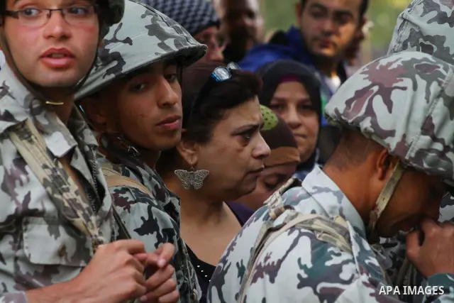 Egyptian soldiers stand guard as voters queue outside a school turned polling station in Cairo on November 28, 2011. Egyptians began voting in the first elections since the fall of autocrat Hosni Mubarak who was ousted i...