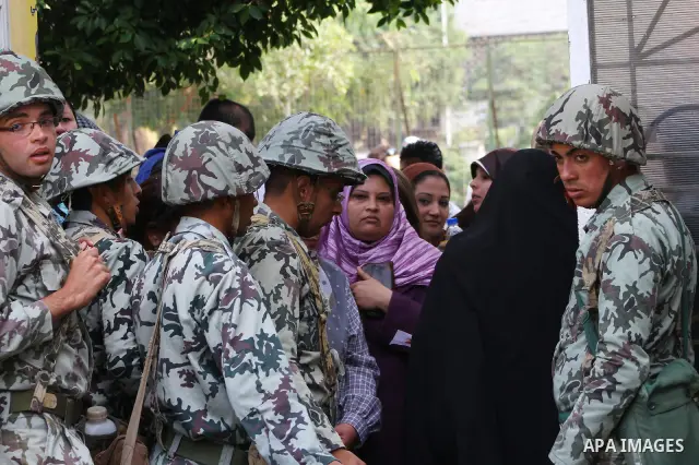 Egyptian soldiers stand guard as voters queue outside a school turned polling station in Cairo on November 28, 2011. Egyptians began voting in the first elections since the fall of autocrat Hosni Mubarak who was ousted i...