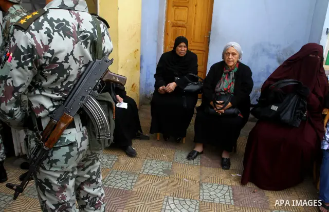 Egyptian soldiers stand guard as voters queue outside a school turned polling station in Cairo on November 28, 2011. Egyptians began voting in the first elections since the fall of autocrat Hosni Mubarak who was ousted i...