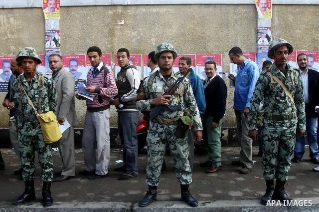 Egyptian soldiers stand guard as voters queue outside a school turned polling station in Cairo on November 28, 2011. Egyptians began voting in the first elections since the fall of autocrat Hosni Mubarak who was ousted i...