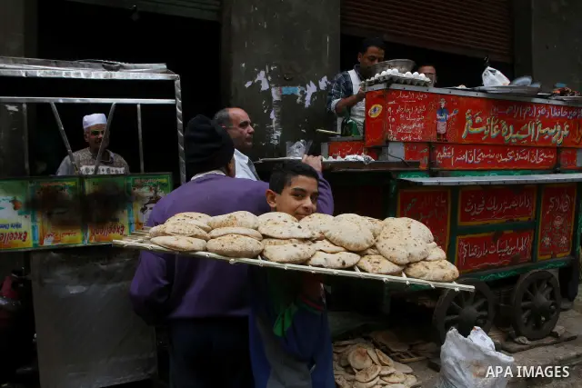 An Egyptian boy carries a tray of traditional bread in Cairo, Egypt, on November 29, 2011. Egypt hailed the start of its first post-revolution election as a triumph for democracy as more voters headed to the polls, boost...