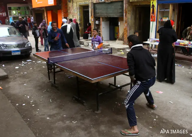 Egyptian youths play table tennis outside their house in Cairo on November 29, 2011. Egypt hailed the start of its first post-revolution election as a triumph for democracy as more voters headed to the polls, boosting tu...