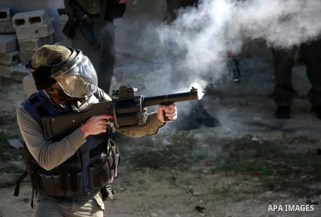 Israeli border police officers fire tear gas towards Palestinian demonstrators, not seen, during a protest in the village of Kufr Qaddum near the Israeli settlement of Kdumim, in the northern West Bank, Friday, Dec. 2, 2...