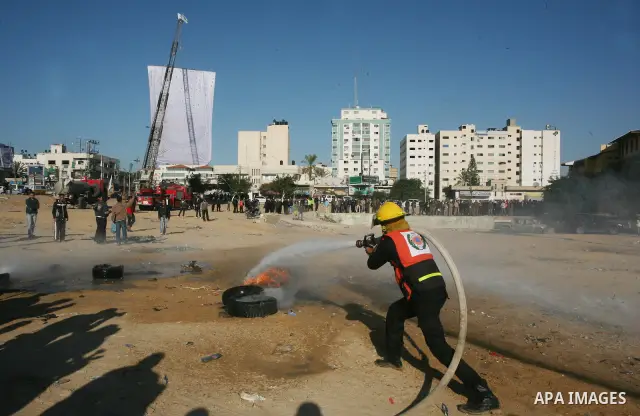 Members of the Palestinian civil defence demonstrate thier skills during a training session following the campaign "your Safety", in Gaza city on Dec. 04, 2011. Photo by Mahmud Nassar