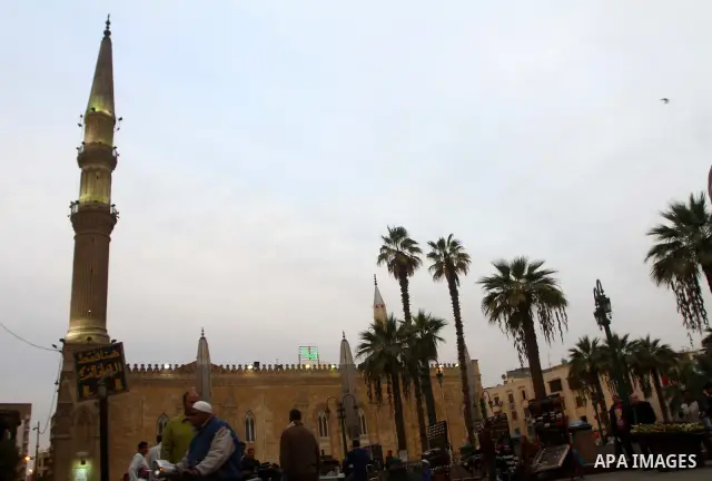 Tourists walk outside the al-Hussein mosque, which according to the belief head of Imam Hussein, the grandson of prophet Mohammed, is buried, in the old city of Cairo on December 4, 2011. Photo by Ashraf Amra
