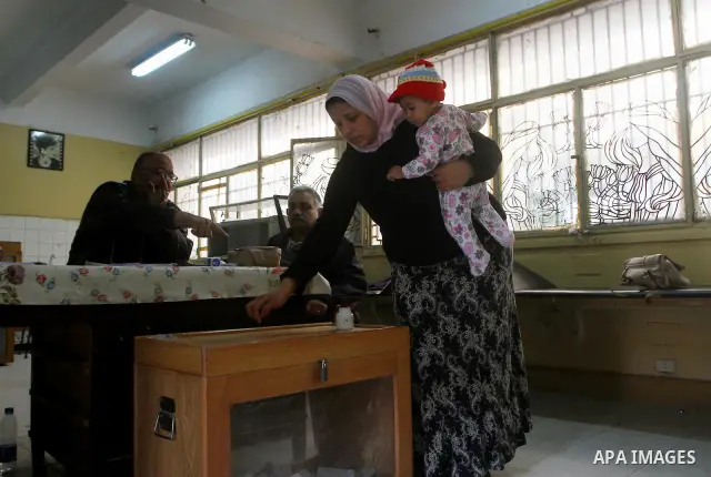 An Egyptian woman votes at a polling center during the first day of runoffs in Cairo, Egypt, Monday, Dec. 5, 2011. A trickle of Egyptian voters headed to the polls Monday for two days of runoffs in the country's first pa...