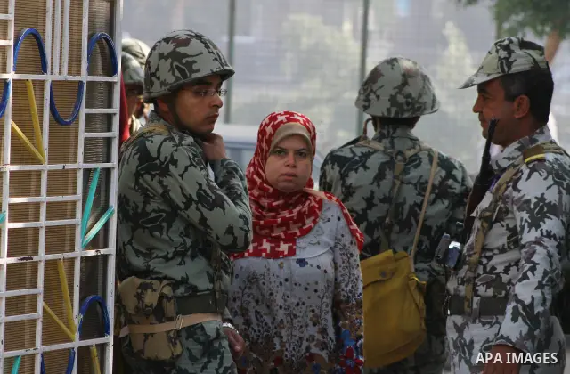 A soldiers stands guard in front of a torn election poster at the entrance of a polling station in the run offof the first round of voting in the Cairo neighbourhood of Zamalek on December 5, 2011. Islamist candidates in...