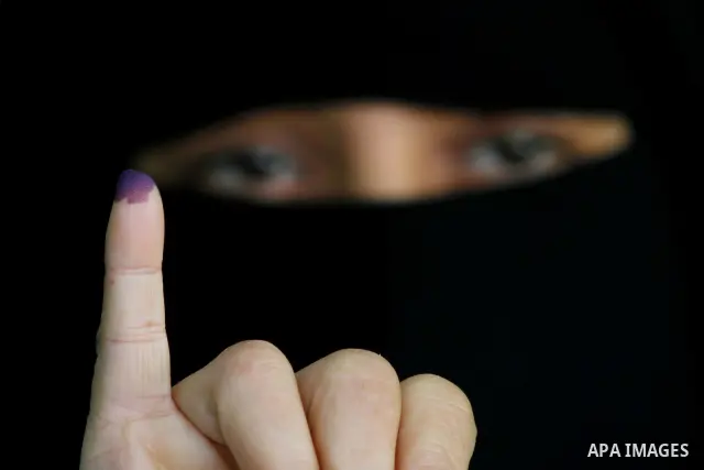 An Egyptian woman shows her ink-stained finger during the run-off of the first round of parliamentary voting in the Cairo neighbourhood of al-Manial on December 5, 2011. Islamist candidates in Egypt looked to extend thei...