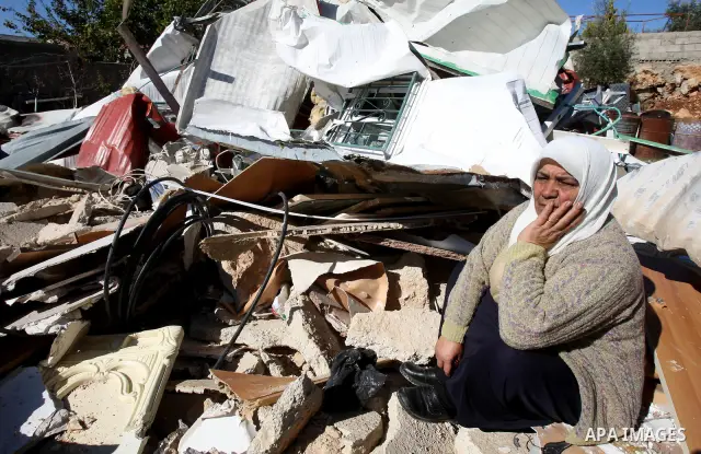 A Palestinian woman reacts after Israeli forces destroyed her family house in an area of the east Jerusalem neighborhood of Beit Hanina which falls in the West Bank side of Israel's separation barrier on Dec. 5, 2011. Ac...