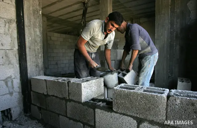 Palestinian laborours work to construct new houses in a project funded by the United Nations Relief and Works Agency for Palestine Refugees (UNRWA) in Rafah, in the southern of Gaza Strip on December 5, 2011. Israel main...