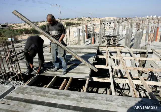 Palestinian laborours work to construct new houses in a project funded by the United Nations Relief and Works Agency for Palestine Refugees (UNRWA) in Rafah, in the southern of Gaza Strip on December 5, 2011. Israel main...