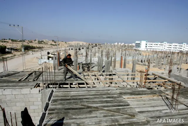 Palestinian laborours work to construct new houses in a project funded by the United Nations Relief and Works Agency for Palestine Refugees (UNRWA) in Rafah, in the southern of Gaza Strip on December 5, 2011. Israel main...