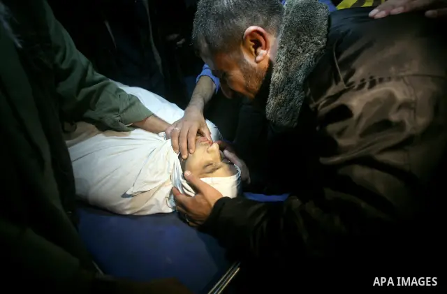 Palestinians people mourn around the body of Islamic Jihad militant Ismail al-Areer who was killed in an Israeli air strike in Gaza City, Gaza, on 07 December 2011. Photo by Mhmoud Nassar