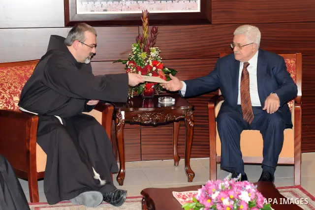 Palestinian President, Mahmoud Abbas (Abu Mazen), receives an invitation to attend the midnight mass at the Church of the Nativity of Father, Ibrahim Faltas, in the West Bank City of Ramallah. Photo by Mufeed Abu Hasna