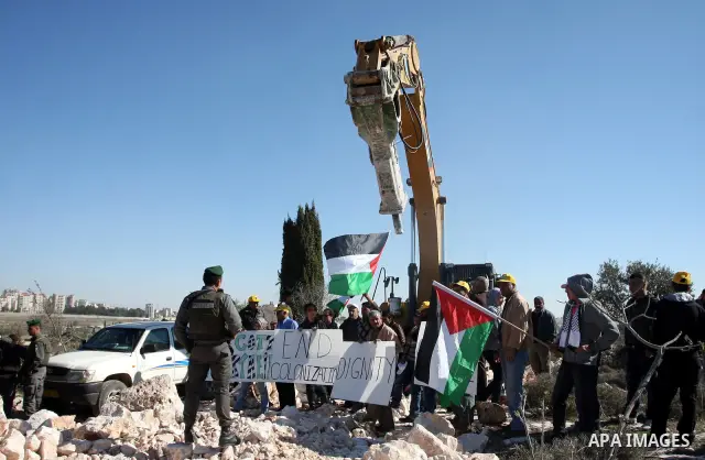 Israeli border police officers scuffle with protesters after they tried to block a construction vehicle from working on Israel's barrier in the West Bank village of Qalandiya near Ramallah December 7, 2011. According to...