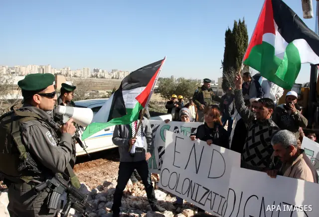 Israeli border police officers scuffle with protesters after they tried to block a construction vehicle from working on Israel's barrier in the West Bank village of Qalandiya near Ramallah December 7, 2011. According to...