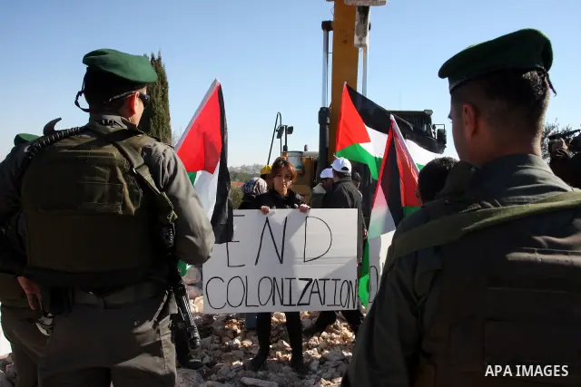 Israeli border police officers scuffle with protesters after they tried to block a construction vehicle from working on Israel's barrier in the West Bank village of Qalandiya near Ramallah December 7, 2011. According to...