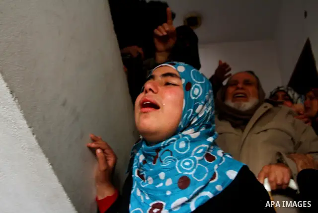 Relative of Palestinians Sobhi al-Batsh, a member of Hamas's armed wing the Ezzedine al-Qassam Brigades, and Issam al-Batsh, a senior member of the Al-Aqsa Martyrs Brigades, mourn at his home during his funeral in Gaza C...