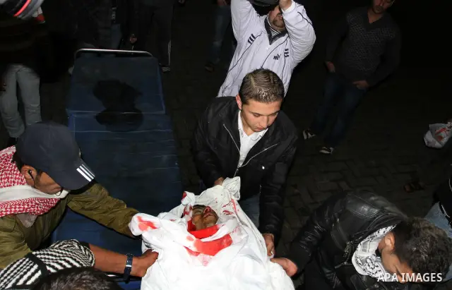Palestinian men wheel a wounded man on a stretcher into al-Shifa hospital in Gaza City on December 9, 2011, after an Israeli air strike. Photo by Mahmud Nassar